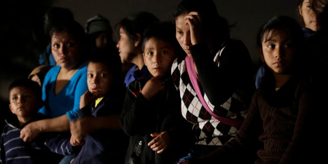 FILE - In this June 25, 2014 photo shows a group of immigrants from Honduras and El Salvador who crossed the U.S.-Mexico border illegally are stopped in Granjeno, Texas. The influx at the border is largely families with children or by minors traveling alone. From October 2012 through the end of September 2013, the U.S. Border Patrol apprehended about 24,000 unaccompanied children. But between October and the end of June 2014, the number shot up to 57,000. Secretary of Homeland Security Jeh Johnson testified recently that the number is accelerating so fast that it could reach 90,000 by the end of September. Most of them are coming from El Salvador, Honduras and Guatemala. (AP Photo/Eric Gay, File)