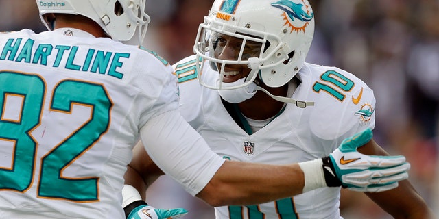 Miami Dolphins wide receiver Brandon Gibson (10) celebrates his touchdown catch against the New England Patriots with Dolphins wide receiver Brian Hartline in the first quarter of an NFL football game on Sunday, Oct. 27, 2013, in Foxborough, Mass. (AP Photo/Steven Senne)