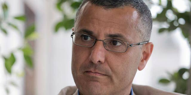 Omar Barghouti listens during an interview with the Associated Press in the West Bank city of Ramallah, Tuesday, May 10, 2016. Barghouti, a Qatari-born Palestinian who is married to an Israeli woman and leader of the international boycott movement against Israel, on Tuesday accused Israeli authorities of imposing a travel ban on him as retribution for his political activities. (AP Photo/Nasser Nasser)