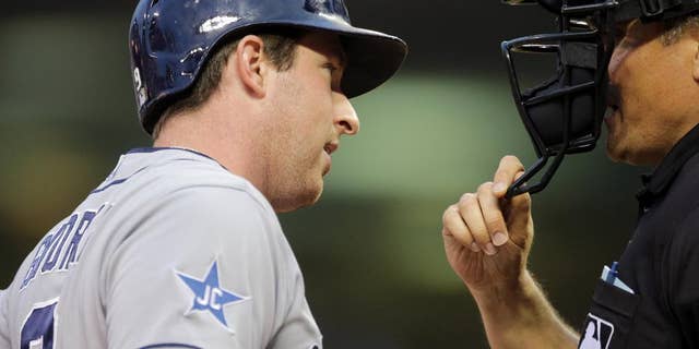 San Diego Padres' Jedd Gyorko, left, questions plate umpire Mike DiMuro after he was called out on strikes in the fourth inning of a baseball game against the Minnesota Twins, Tuesday, Aug. 5, 2014, in Minneapolis. (AP Photo/Jim Mone)