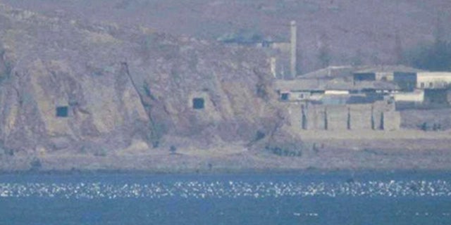 FILE: Two caves with coastal artillery, left, are seen at the North Korean village of Haeju where North Korea's military units are stationed.