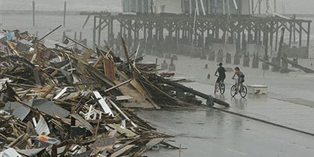 Sept. 14: Cyclists ride past debris piled up on the seawall road after Hurricane Ike hit the Texas coast.