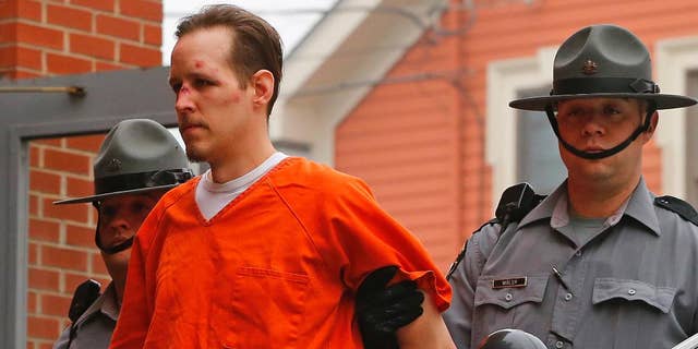 FILE - In this Oct. 31, 2014 file photo Eric Frein is escorted by police into the Pike County Courthouse for his arraignment in Milford, Pa. Frein a survivalist who eluded capture for 48 days after allegedly killing a trooper in a 2014 ambush says police were about a football field away from him at one point during the manhunt. Authorities say they found Eric Frein’s journal at the airplane hangar where he was hiding out until his arrest. A trooper testified about the journal at Frein’s capital murder trial Wednesday, April 12, 2017.   (AP Photo/Rich Schultz, File)
