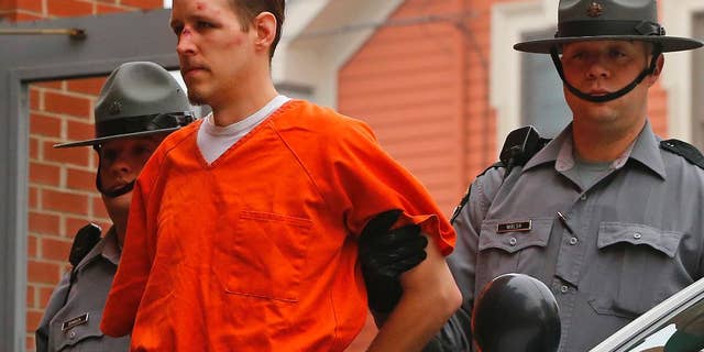 FILE - In this Oct. 31, 2014 file photo Eric Frein is escorted by police into the Pike County Courthouse for his arraignment in Milford, Pa. Frein a survivalist who eluded capture for 48 days after allegedly killing a trooper in a 2014 ambush says police were about a football field away from him at one point during the manhunt. Authorities say they found Eric Frein’s journal at the airplane hangar where he was hiding out until his arrest. A trooper testified about the journal at Frein’s capital murder trial Wednesday, April 12, 2017. (AP Photo/Rich Schultz, File)