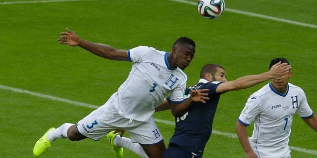 Honduras' Maynor Figueroa, left, and France's Karim Benzema challenge for the ball during the group E World Cup soccer match between France and Honduras at the Estadio Beira-Rio in Porto Alegre, Brazil, Sunday, June 15, 2014. (AP Photo/Andrew Medichini)