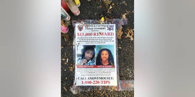 A poster featuring photos of Nisa Mickens and Kayla Cueva, part of a memorial near the spot where their bodies were found in Brentwood.