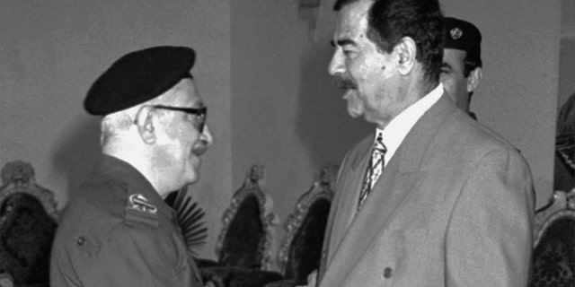 In this Jan. 29, 1998 file photo, Iraqi Deputy Premier Tariq Aziz, left, greets President Saddam Hussein on Eid al-Fitr, the end of Ramadan in Baghdad, Iraq.