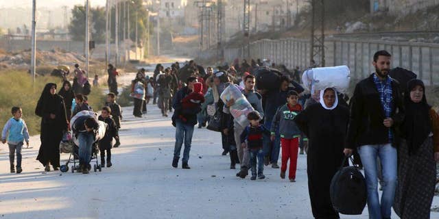 FILE - In this Sunday, Nov. 27, 2016 file photo provided by the Rumaf, a Syrian Kurdish activist group, which has been authenticated based on its contents and other AP reporting, shows people fleeing rebel-held eastern neighborhoods of Aleppo into the Sheikh Maqsoud area that is controlled by Kurdish fighters, Syria. The U.N. humanitarian aid agency said Friday an estimated 31,500 have been displaced from the government advances into the rebel-held enclave since this weekend, in one of the most dramatic shifts in the conflict now in its sixth year. (The Rumaf via AP, File)