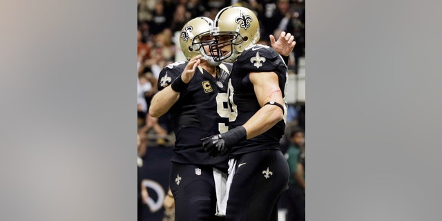 New Orleans Saints quarterback Drew Brees (9) congratulated tight end Jimmy Graham after Graham's touchdown reception during the second half of an NFL football game against the Carolina Panthers Sunday, Dec. 30, 2012, in New Orleans. (AP Photo/Dave Martin)