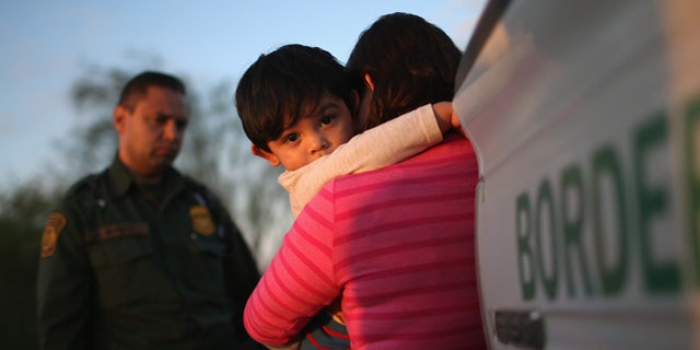 RIO GRANDE CITY, TX - DECEMBER 07: A one-year-old from El Salvador clings to his mother after she turned themselves in to Border Patrol agents on December 7, 2015 near Rio Grande City, Texas. They had just illegally crossed the U.S.-Mexico border into Texas. The mother said she brought her son on the 24-day journey from El Salvador to escape violence in the Central American country. The number of migrant families and unaccompanied minors has again surged in recent months, even as the total number of illegal crossings nationwide has gone down over the previous year. (Photo by John Moore/Getty Images)