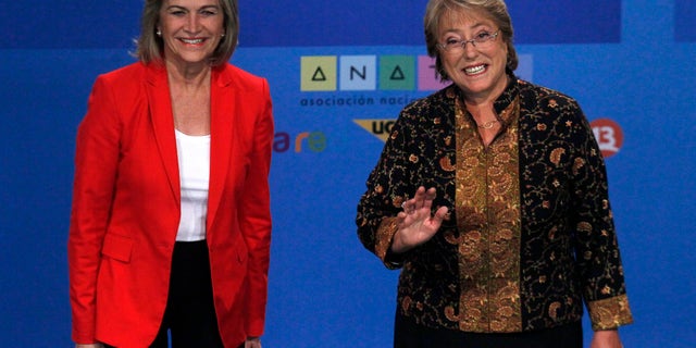 In this Tuesday, Dec. 10, 2013 photo, Chile's presidential candidate Michelle Bachelet, right, and rival Evelyn Matthei, smile for photographers before their television debate in Santiago, Chile. Bachelet and Matthei were childhood friends, but found themselves on opposite sides of the deep political divide after Chile's bloody 1973 military coup. Bachelet, who became Chile's first women president from 2006-2010, is now expected to retake the presidency in the Dec. 15 run-off election. (AP Photo/ Luis Hidalgo)