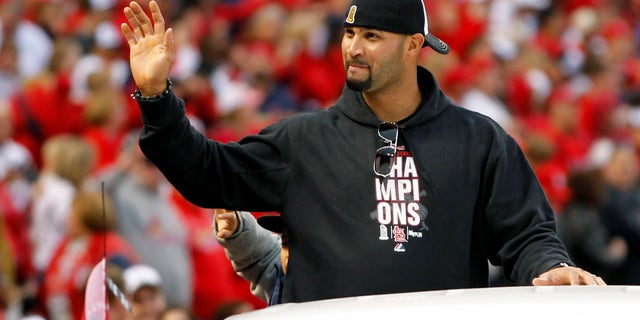 FILE - In this Oct. 30, 2011, file photo, former St. Louis Cardinals player Albert Pujols waves to fans at Busch Stadium during a parade in celebration of the Cardinals' 11th World Series victory in St. Louis. Pujols’ exit had no effect on the Cardinals, who have not missed the three-time NL MVP. (AP Photo/Jeff Roberson, File)