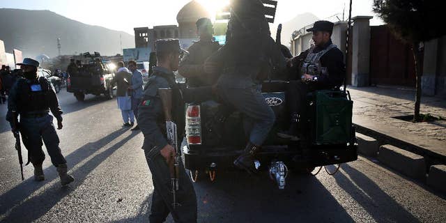 FILE - In this Saturday, Feb. 27, 2016 file photo, Afghan National Police soldier leave the site of a suicide attack near the Defense Ministry compound, in Kabul, Afghanistan. Senior members of the Afghan Taliban said on Thursday that a prominent figure within the militant group who had opposed its new leadership has now pledged his allegiance, helping to close divisions within the Taliban ahead of possible peace talks with the government. (AP Photos/Massoud Hossaini, File)