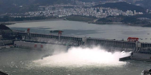 In this Nov. 7, 2008 photo, the flow of water is discharged through the Three Gorges Dam in Yichang in central China's Hubei province. State-owned China Three Gorges Group is spending heavily to buy or build hydro, wind and solar projects at a time when Western utility investors are pulling back and U.S. President-elect Donald Trump’s pledge to revive coal use has raised doubt about U.S. support for renewables. (Chinatopix via AP)