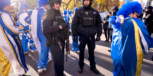 New York Police Department officers hold their position as parade participants walk around them during the Macy's Thanksgiving Day Parade in New York on Thursday, Nov. 23, 2017. This year's procession has been redesigned because of the coronavirus pandemic. (AP Photo/Craig Ruttle)