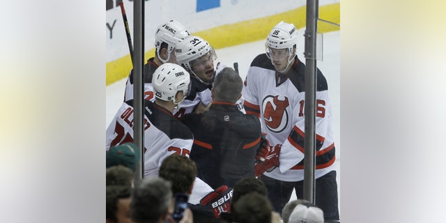 New Jersey Devils defenseman Jon Merrill (34) is helped up from the ice after he was tripped by Minnesota Wild center Torrey Mitchell during the first period of an NHL hockey game in St. Paul, Minn., Sunday, Nov. 3, 2013. Merrill left the game. (AP Photo/Ann Heisenfelt)