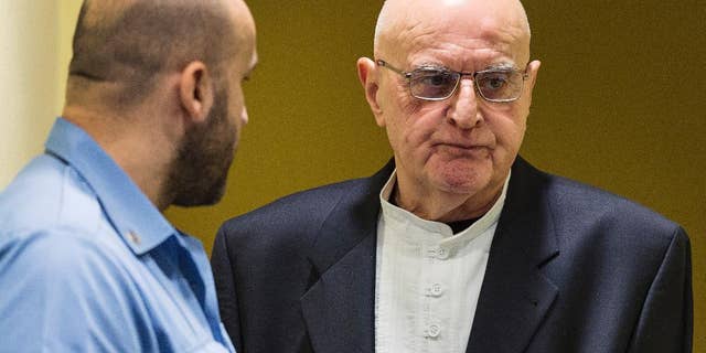 FILE - In this Jan. 30, 2015 file picture Ljubisa Beara, right, enters the courtroom of the International Criminal Tribunal for the former Yugoslavia (ICTY) in The Hague, Netherlands. The Bosnian Serb commander convicted of war crimes over the 1995 Srebrenica massacre has died in a German prison. He was 77. A spokeswoman for Berlin state's justice department told The Associated Press on Friday Feb. 10, 2017 that Ljubisa Beara died Feb. 8. (AP Photo/Michael Kooren, Pool, file )