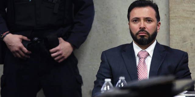 In this Monday, April 20, 2015 photo, Chicago police Detective Dante Servin listens as Judge Dennis Porter reads his decision at the Leighton Criminal Court Building in Chicago on involuntary manslaughter charges in the March 2012 shooting death of Rekia Boyd. Porter ruled that prosecutors failed to prove Servin acted recklessly, by the legal definition. Demonstrators rallied Monday night to protest the acquittal. (John J. Kim/Chicago Tribune via AP, Pool)