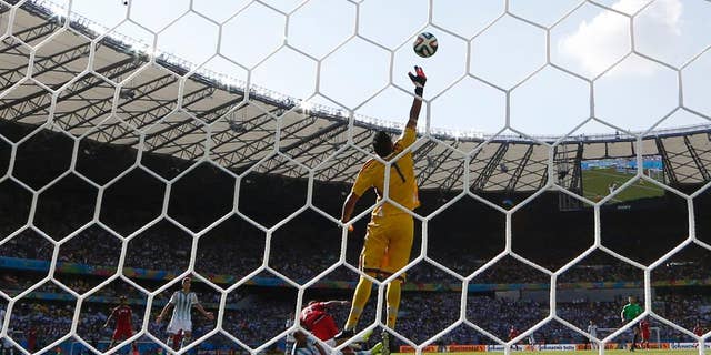 Argentina's goalkeeper Sergio Romero deflects a header by Iran's Ashkan Dejagah over the goal during the group F World Cup soccer match between Argentina and Iran at the Mineirao Stadium in Belo Horizonte, Brazil, Saturday, June 21, 2014. (AP Photo/Fernando Vergara)