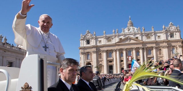Pope Francis blesses the crowd as he leaves after a Palm Sunday Mass he celebrated in St. Peter's Square, at the Vatican, Sunday, March 29, 2015. Pope Francis walked solemnly through St. Peter's Square in a Palm Sunday procession to usher in Holy Week ahead of Easter. (AP Photo/Andrew Medichini)