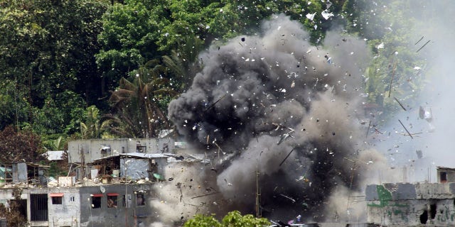 June 20: Debris and smoke are seen after an OV-10 Bronco aircraft released a bomb during an airstrike, as government forces continue their assault against insurgents from the Maute group, who have taken over large parts of Marawi City.