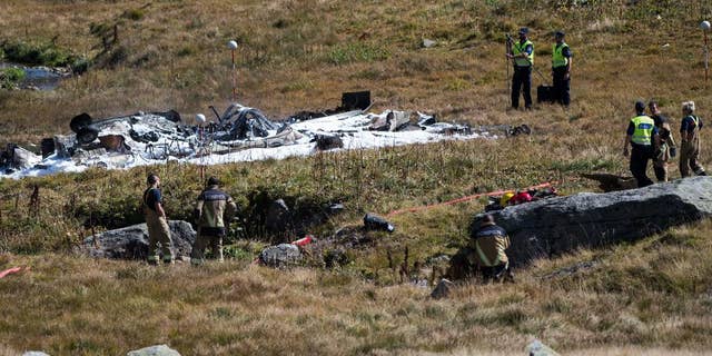 Rescue workers stand arround the debris oft the crashed Swiss army helicopter in the Alps near the Gotthard mountain pass in Airolo, southern Switzerland, Wednesday, Sept. 28 2016. The head of Switzerland’s air force says one of its Super Puma helicopters has crashed, killing two pilots on board and injuring a flight assistant. (Samuel Golay/Ti-Press/Keystone via AP)