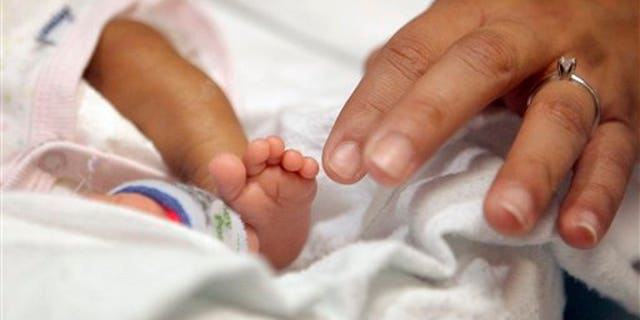 Haydee Ibarra, right, touches her 14-week-old daughter, Melinda Star Guido's toes at the Los Angeles County-USC Medical Center in Los Angeles, Wednesday, Dec. 14, 2011. At birth, Melinda Star Guido tipped the scales at only 9 1/2 ounces, a tad less than the weight of two iPhone 4S. Most babies her size dont survive, but doctors are preparing to send her home as soon as the end of the month. Melinda is believed to be the second smallest baby to survive in the United States and the third smallest in the world. (AP Photo/Jae C. Hong)