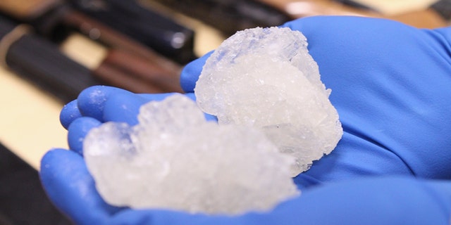 AUCKLAND, NEW ZEALAND - AUGUST 19: Detective Paul Baker holds two rocks of crystal meth with a street value of NZD,000 alongside firearms that were confiscated as part of Operation Slab at the North Shore Policing Centre on August 19, 2010 in Auckland, New Zealand. Police executed 22 search warrants across New Zealand and raided six crime labs resulting in the seizure of 140 grams of crystal meth, weapons and drug manufacturing equipment. Ten suspects were arrested as a part of the raid and will appear in the Auckland District Court. (Photo by Phil Walter/Getty Images) *** Local Caption *** Paul Baker