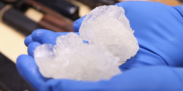 AUCKLAND, NEW ZEALAND - AUGUST 19: Detective Paul Baker holds two rocks of crystal meth with a street value of NZD$83,000 alongside firearms that were confiscated as part of Operation Slab at the North Shore Policing Centre on August 19, 2010 in Auckland, New Zealand. Police executed 22 search warrants across New Zealand and raided six crime labs resulting in the seizure of 140 grams of crystal meth, weapons and drug manufacturing equipment. Ten suspects were arrested as a part of the raid and will appear in the Auckland District Court. (Photo by Phil Walter/Getty Images) *** Local Caption *** Paul Baker