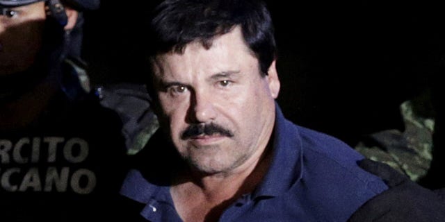 Recaptured drug lord Joaquin "El Chapo" Guzman is escorted by soldiers at the hangar belonging to the office of the Attorney General in Mexico City, Mexico January 8, 2016.