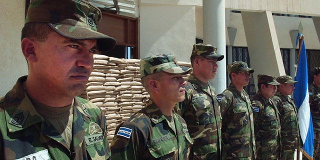 AN NAJAF, IRAQ - MARCH 23: An El Salvadoran military unit stands at attention prior to a visit by Chief American Coalition Provisional Authority Administrator J. Paul Bremer March 23,2004 to thank them in in Najaf, Iraq. The unit fought off an small arms and rpg attack on a CPA convoy recently between Hilla and Najaf. Bremer participated in a series of press events today designed to mark the beginning of the 100 Day countdown to the handover of power back to Iraqis scheduled for June 30, 2004. In addition to congratulating the El Salvadoran military unit, Bremer also visited the Najaf power plant, and conducted a town hall style meeting in Najaf with local clerics, politicians, and security officials (Pool/Photo by Scott Nelson/Getty Images) *** Local Caption *** J. Paul Bremer