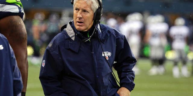 Seattle Seahawks head coach Pete Carroll wears a headset as he walks on the sideline during the second half of an NFL football game against the Oakland Raiders, Sunday, Nov. 2, 2014, in Seattle. (AP Photo/Elaine Thompson)