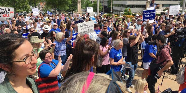 Protesters gather outside the state Capitol building on Friday, April 14, 2017, in Little Rock, Ark., to voice their opposition to Arkansas' seven upcoming executions. (AP Photo/Kelly P. Kissel)