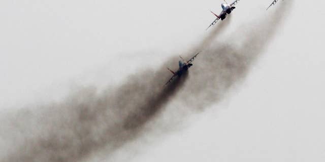 FILE - In this Sept 1, 2012 file photo, a Mig-29 jet fighters of Russian aerobatic team Strizhi (Swifts) perform during air-show in Batajnica, military airport near Belgrade, Serbia. NATO is holding an emergency exercise drill in Montenegro while Russia's troops will participate in a war game in Serbia as the two Balkans neighbors that seem to be heading different directions strategically. (AP Photo/Darko Vojinovic, File)