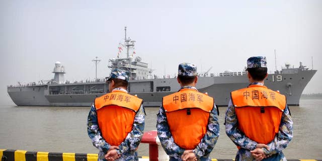 FILE - In this May 6, 2016, file photo, soldiers from the Chinese People's Liberation Army (PLA) Navy watch as the USS Blue Ridge arrives at a port in Shanghai. Seeking to calm escalating tensions in the South China Sea, top generals from China and the U.S. spoke by phone Thursday, May 12, 2016, and said they were ready to work out an effective mechanism to prevent confrontation and maintain stability in the region. (AP Photo, File)