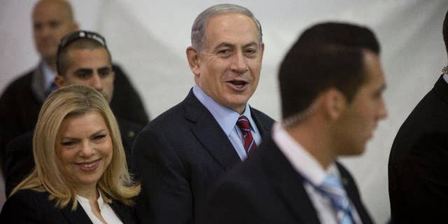 FILE - In this Wednesday, Dec. 31, 2014 file photo, Israeli Prime Minister Benjamin Netanyahu and his wife Sarah arrive for the Likud party primary elections in Jerusalem. Israel's attorney general has ordered a criminal investigation into excessive spending at Netanyahu's residences. The announcement followed a report by the state comptroller, an official watchdog body, that cited large sums of public money spent on food, furniture, cleaning and gardening at Netanyahu and his wife's official residence in Jerusalem and their private home in the exclusive coastal city of Caesarea. (AP Photo/Oded Balilty, File)