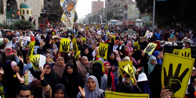 Supporters of ousted President Mohammed Morsi show their symbolic sign of four fingers to commemorate the protesters killed and injured during the Aug. 14 dispersal while marching on a street in Cairo, Egypt, Friday, Feb. 14, 2014. Morsi supporters had camped out in two locations in Cairo for nearly two months before police moved in to break up the sit-in encampments on Aug. 14 last year, killing at least 600. (AP Photo/El Shorouk newspaper, Ahmed Abdel Fattah) EGYPT OUT
