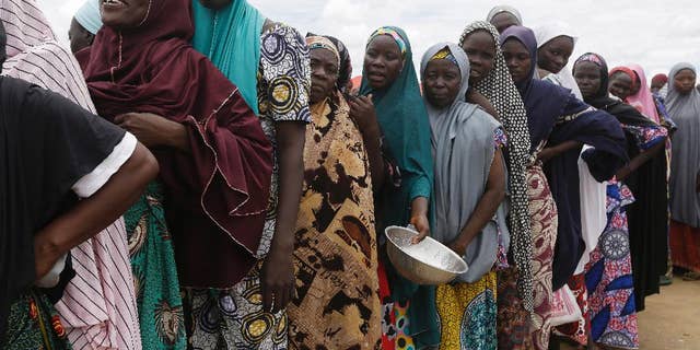 FILE-In this file photo taken Saturday, Aug. 27, 2016, women displaced by Islamist extremists wait for food to be handed out to them at the Bakassi camp in Maiduguri, Nigeria. Many say the dangerous journey is preferable to the hunger, humiliation and inhumane conditions in refugee camps where more than 1 million Nigerians, displaced by Boko Haram, are waiting to go home.