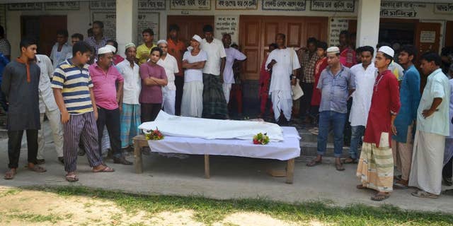 Locals surround the body of a Hindu holy man after assailants hacked him to death in Pabna, 275 kilometres (170 miles) from Dhaka, Friday, June 10, 2016. Pabna district police chief Alamgir Kabir said that radical Islamists are suspected of carrying out the attack on 60-year-old Nitya Ranjan Pandey while he was taking a walk at dawn near his ashram. (AP Photo)