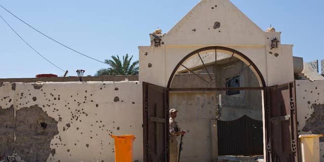 A Christian militiaman stands guard during Easter Mass in Qaraqosh, Iraq, Sunday, April 16 2017. The town has been gutted by Islamic State militants. Now under government control, residents have not returned. (AP Photo/Maya Alleruzzo)