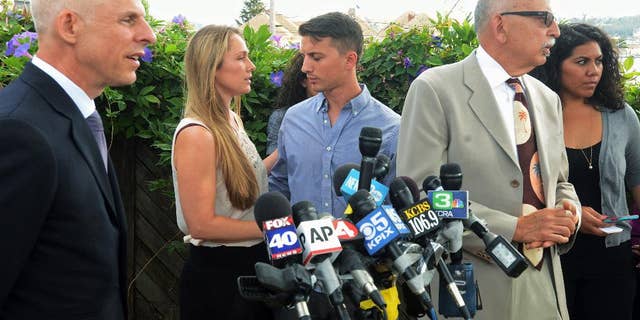 Denise Huskins, second from left, and her boyfriend, Aaron Quinn, turn to each other at the end of a news conference on Monday, July 13, 2015, in Vallejo, Calif. At left is Huskins' attorney, Douglas Rappaport and second from right is Quinn's attorney, Daniel Russo. The lawyers for the couple in the kidnap-for-ransom case that police called a hoax are blasting investigators and asking that authorities set the record straight. (Mike Jory/Vallejo Times-Herald via AP)