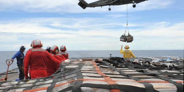 In this March 12, 2011 photo provided by the U.S. Navy, sailors aboard the U.S. 7th Fleet command ship USS Blue Ridge (LCC 19) stand-by to move pallets of humanitarian relief supplies across the ship's flight deck during an underway replenishment with the Military Sealift Command fleet replenishment oiler USNS Rappahannock (T-AO 204), not pictured. (AP Photo/U.S. Navy, Fidel C. Hart)