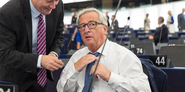 The head of the European Union's executive, Jean-Claude Juncker, adjusts his tie next to the head of the president's cabinet, Martin Selmayer, left, as he prepares to deliver his State of the Union address at the European Parliament in Strasbourg, eastern France, Wednesday, Sept. 14, 2016. EU Commission President Jean-Claude Juncker said in his State of the European Union address to the European parliament that the EU "still does not have enough Union."(AP Photo/Jean-Francois Badias)
