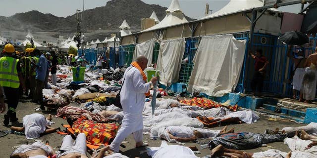 FILE - In this Thursday, Sept. 24, 2015 file photo, a Muslim pilgrim walks through the site where dead bodies are gathered in Mina, Saudi Arabia during the annual hajj pilgrimage. The crush and stampede that struck the hajj last month in Saudi Arabia killed at least 2,121 pilgrims, a new Associated Press tally showed Monday, after officials in the kingdom met to discuss the tragedy. (AP Photo, File)