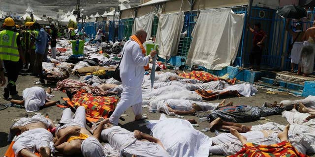 FILE - In this Thursday, Sept. 24, 2015 file photo, a Muslim pilgrim walks through the site where dead bodies are gathered in Mina, Saudi Arabia during the annual hajj pilgrimage. The crush and stampede that struck the hajj last month in Saudi Arabia killed at least 2,121 pilgrims, a new Associated Press tally showed Monday, after officials in the kingdom met to discuss the tragedy. (AP Photo, File)