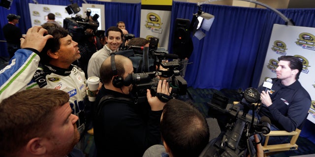 Driver/owner Michael Waltrip, left, jokes with driver Denny Hamlin, right, about his hair during a news conference at the NASCAR Sprint Cup auto racing Media Tour in Charlotte, N.C., Thursday, Jan. 30, 2014. (AP Photo)