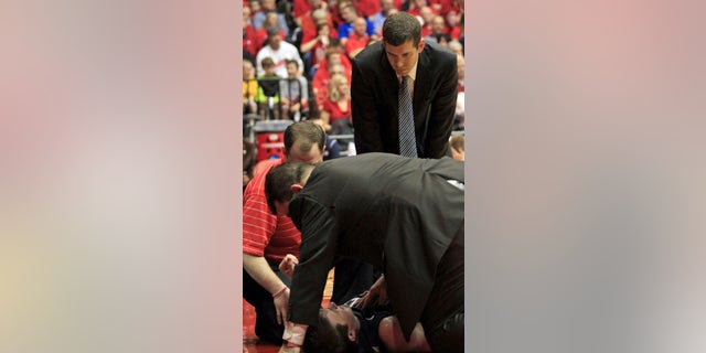 Butler head coach Brad Stevens looks on as his trainers attend to Rotnei Clarke after Clarke was injured during the first half of an NCAA college basketball game against Dayton, Saturday, Jan. 12, 2013, in Dayton, Ohio. Clarke was taken from the arena on a backboard.(AP Photo/Skip Peterson)