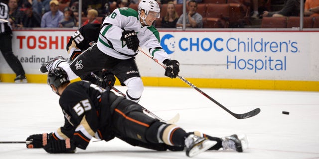 Dallas Stars center Ryan Garbutt, top, shoots and scores as Anaheim Ducks defenseman Bryan Allen defends during the first period of their NHL hockey game, Sunday, Oct. 20, 2013, in Anaheim, Calif. (AP Photo/Mark J. Terrill)