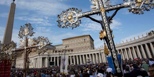 Crucifixes are displayed as Pope Francis delivers his blessing from his studio window overlooking St. Peter's Square at the Vatican, during the Angelus prayer, Sunday, Oct. 23, 2016.