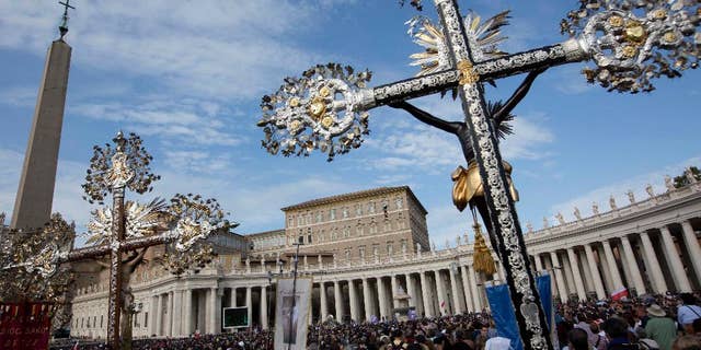 Crucifixes are displayed as Pope Francis delivers his blessing from his studio window overlooking St. Peter's Square at the Vatican, during the Angelus prayer, Oct. 23, 2016.